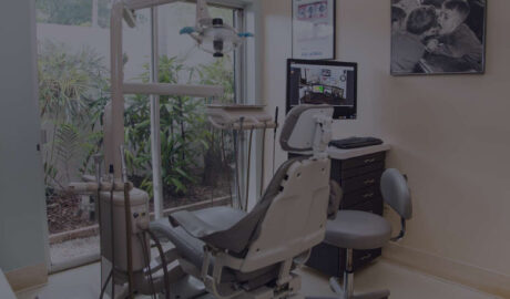 Image shows a dental clinic with a table in a corner. On the table is a desktop with the website of the clinic.