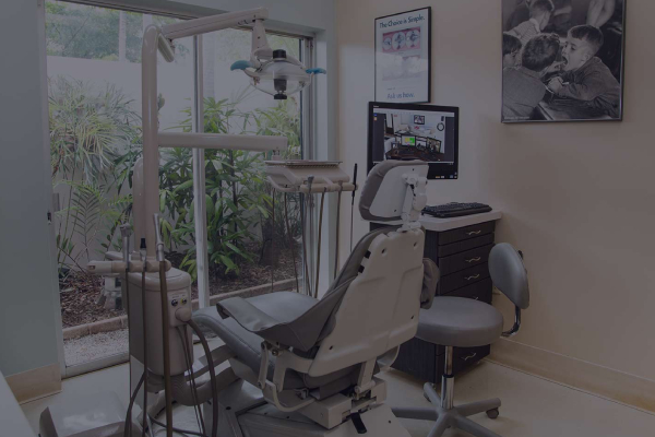 Image shows a dental clinic with a table in a corner. On the table is a desktop with the website of the clinic.